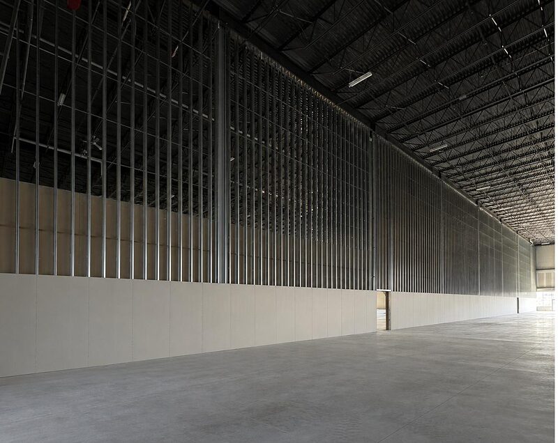 Tall interior steel-stud wall framing in a commercial building